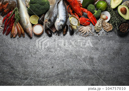 Fresh fish and different seafood on grey table, flat lay. Space for text 104757010