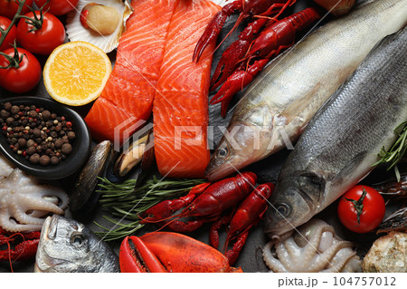Fresh fish and different seafood on table, flat lay Fresh fish and different seafood on table, flat lay 104757012