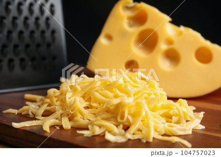 Tasty grated cheese on wooden table, closeup 104757023