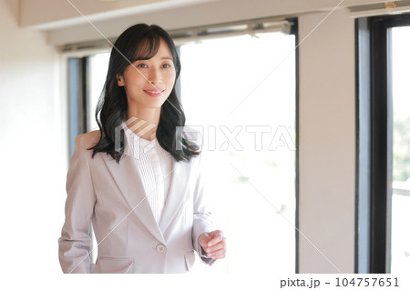 オフィスを歩くロングヘアのビジネスウーマン_2 オフィスを歩くロングヘアのビジネスウーマン_2 104757651
