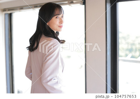 振り返るタブレットを持つロングヘアの女性_2 振り返るタブレットを持つロングヘアの女性_2 104757653