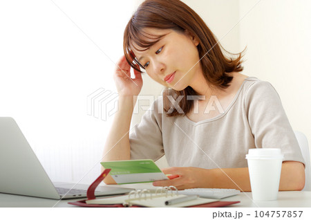 お金の計算をする若い女性 お金の計算をする若い女性 104757857