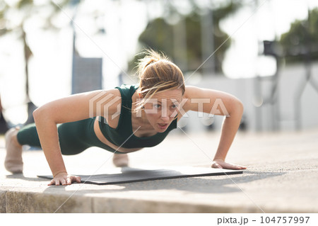 Adult sportive woman with no make up doing push ups 104757997