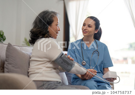 nurse doctor using digital tonometer check blood pressure for old asia female at home in elderly care cardiovascular medical visit, cholesterol problem. Home health care and nursing home concept 104758737