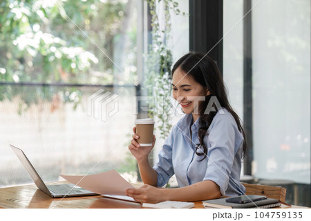 business woman holding a cup of coffee and document at office 104759135