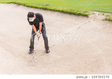 バンカーからゴルフボールを出すゴルファーの男性(バンカーショット) バンカーからゴルフボールを出すゴルファーの男性(バンカーショット) 104760170