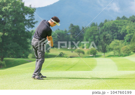 ゴルフ場でアイアンショットをするゴルファーの男性 104760199