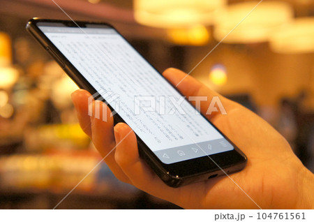 カフェでスマホの小説を読む カフェでスマホの小説を読む 104761561
