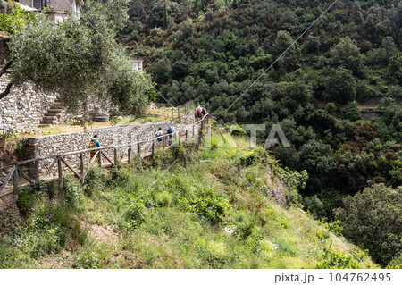 Unrecognized hikers trekking along the scenic Vernazza Monterosso trail in the popular 5 villages Cinque Terre trail in Italy 104762495