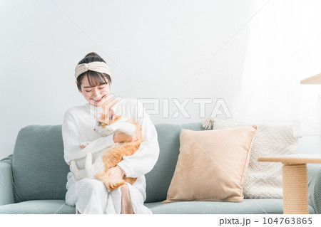家で猫を抱っこする日本人女性（ペット・飼い主） 104763865