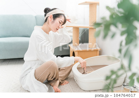 猫用トイレの猫砂を掃除するアジア人女性 猫用トイレの猫砂を掃除するアジア人女性 104764017