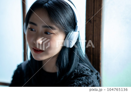ヘッドホンで音楽を聴く若い女性 ヘッドホンで音楽を聴く若い女性 104765136
