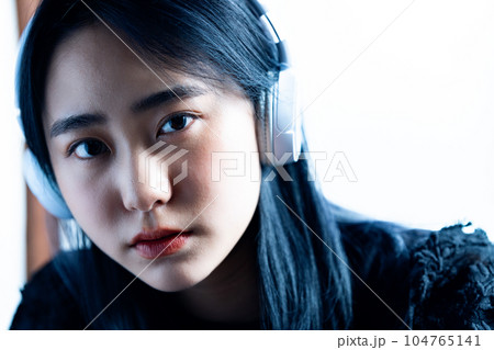 ヘッドホンで音楽を聴く若い女性 104765141