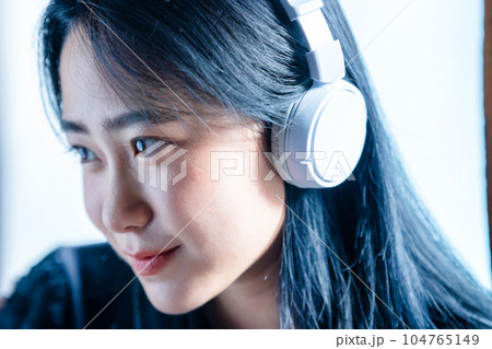 ヘッドホンで音楽を聴く若い女性 ヘッドホンで音楽を聴く若い女性 104765149