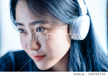 ヘッドホンで音楽を聴く若い女性 ヘッドホンで音楽を聴く若い女性 104765150