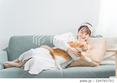 家で猫と遊ぶ日本人女性（嫌がる・抱っこ嫌い） 104765701