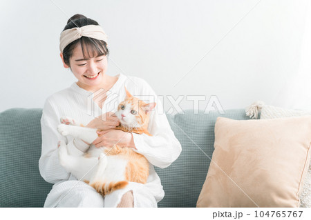 家で猫を抱っこする日本人女性（ペット・飼い主） 104765767
