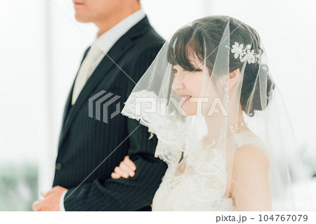 結婚式場で新郎の待つチャペルまでバージンロードを歩く新婦・花嫁の女性 結婚式場で新郎の待つチャペルまでバージンロードを歩く新婦・花嫁の女性 104767079