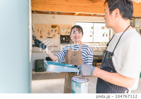 壁の塗装をする日本人の男女の後ろ姿（DIY・リノベーション・リフォーム） 104767112