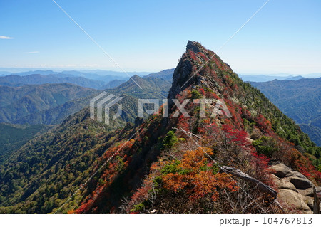 秋晴れの青空を背景に紅葉に染まる石鎚山天狗岳 Ver1 104767813