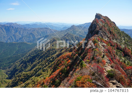 秋晴れの青空を背景に紅葉に染まる石鎚山天狗岳 Ver3 104767815