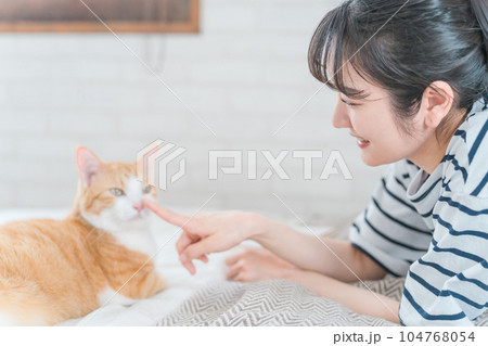 家のベッドルームでペットの猫の鼻を触るアジア人女性(アニマルセラピー・スキンシップ) 家のベッドルームでペットの猫の鼻を触るアジア人女性(アニマルセラピー・スキンシップ) 104768054