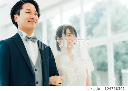 チャペル・式場に入場するバージンロードを歩く新郎新婦の後ろ姿 104768501