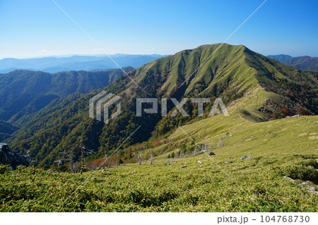 秋晴れの青空を背景に紅葉色づき始めた四国剣山地次郎岌の峰　Ver1 104768730