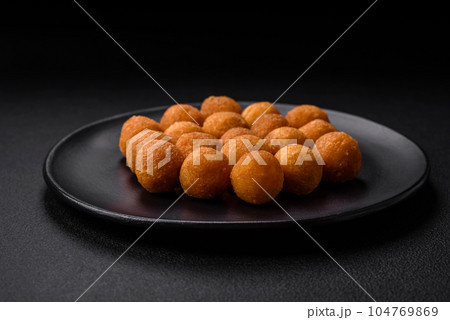 Delicious fried potato balls with breaded mozzarella, salt, spices and herbs 104769869