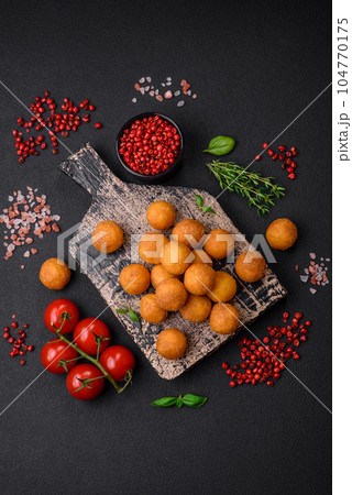 Delicious fried potato balls with breaded mozzarella, salt, spices and herbs 104770175