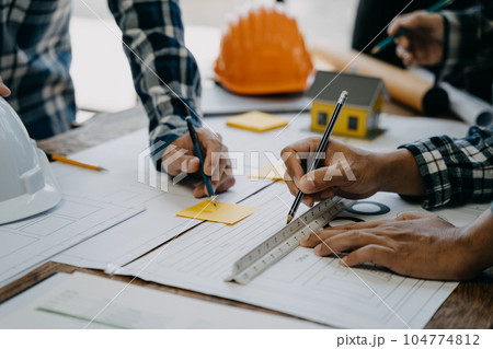 Working as a team architect and designer working on blueprint project of new apartments. Photo concept of work on technical drawings in office. Working as a team architect and designer working on blueprint project of new apartments. Photo concept of work on technical drawings in office. 104774812