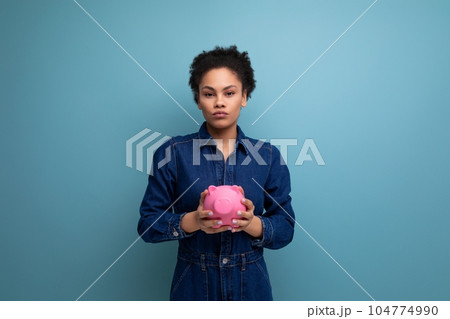 young pretty brunette latin woman with afro hair gathered in a ponytail dressed in denim clothes young pretty brunette latin woman with afro hair gathered in a ponytail dressed in denim clothes 104774990
