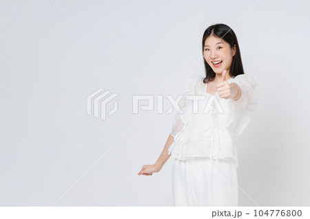 Young  woman showing thumbs up isolated on white background. 104776800
