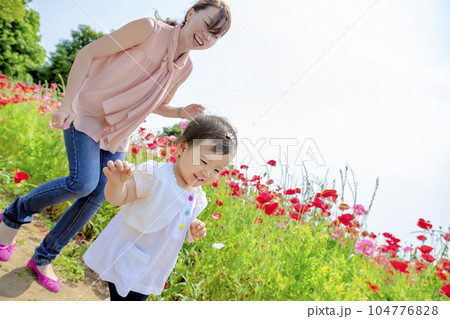 ポピーの咲く丘で遊ぶ母親と娘 104776828