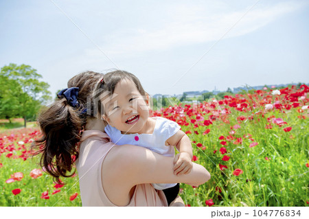 ポピーの咲く丘で遊ぶ母親と娘 104776834