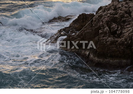 Sea waves crashing against the rocks of mediterranean shore Sea waves crashing against the rocks of mediterranean shore 104778098
