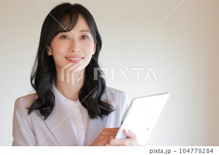 タブレットを操作するロングヘアのビジネスウーマン_3 タブレットを操作するロングヘアのビジネスウーマン_3 104778284