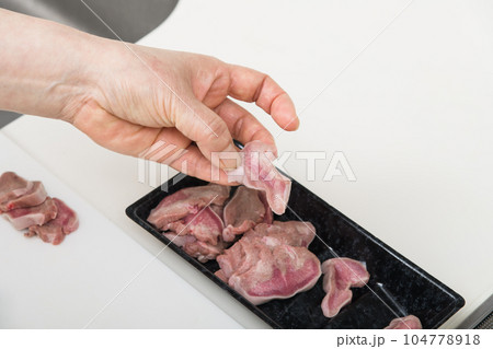 【焼き鳥豚タンの下処理をする主婦】 104778918
