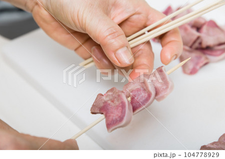 【焼き鳥豚タンの串打ちをする主婦】 104778929