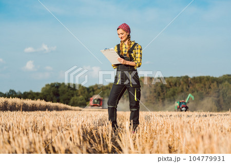 Farmer woman monitoring business progress of the harvest Farmer woman monitoring business progress of the harvest 104779931