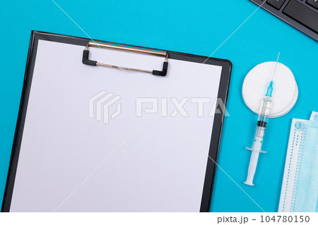 Vaccination or Revaccination Concept - A Medical Syringe on Blue Table Vaccination or Revaccination Concept - A Medical Syringe on Blue Table 104780150