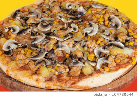Pizza with bacon cheese and herbs on a wooden plate with cheese and cherry tomatoes. On a colored background. 104780644