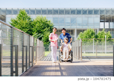 車椅子のシニア女性と若い介護スタッフ 104781475
