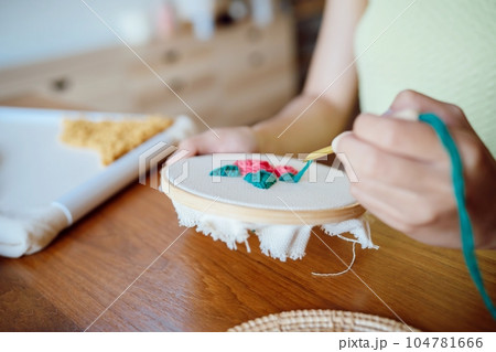 Punch needle. Asian Woman making handmade Hobby knitting in studio workshop. designer workplace Handmade craft project DIY embroidery concept. 104781666