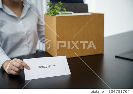 Business woman sending resignation letter to boss and Holding Stuff Resign Depress or carrying cardboard box by desk in office Business woman sending resignation letter to boss and Holding Stuff Resign Depress or carrying cardboard box by desk in office 104781704
