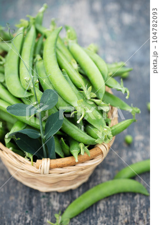 peas in a wicker basket on a rustic background 104782093