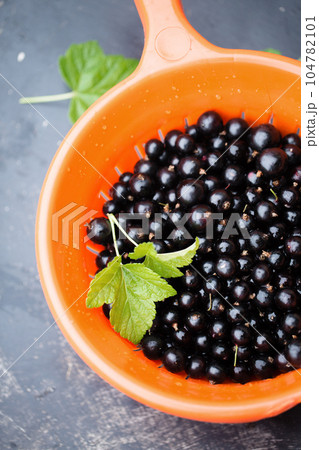 Blackberry in an orange sieve Blackberry in an orange sieve 104782101