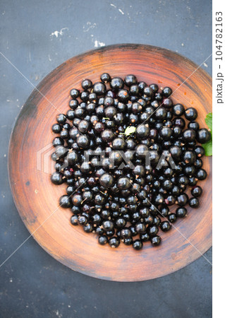 black currants in a large wooden bowl 104782163