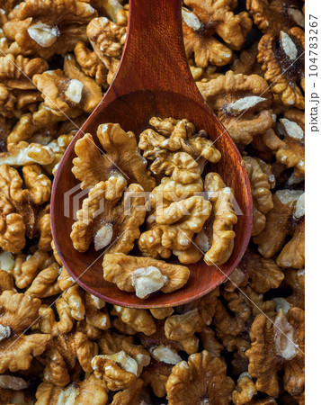 Peeled walnut lies in wooden spoon. Top view. Advertising photo for selling nuts on marketplaces Peeled walnut lies in wooden spoon. Top view. Advertising photo for selling nuts on marketplaces 104783267