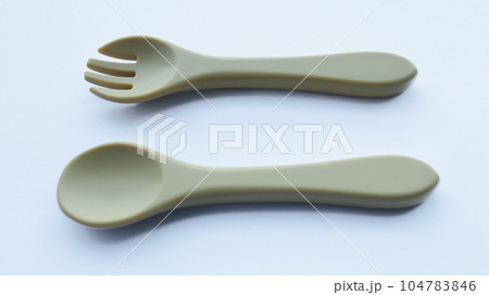 Brown silicone fork and spoon baby utensil isolated on white. Brown silicone fork and spoon baby utensil isolated on white. 104783846